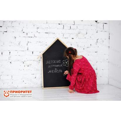 Девочка рисует на грифельной доске мелом